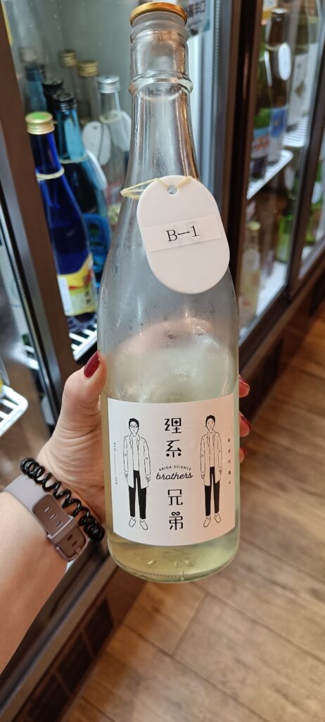 A hand holding a bottle of sake in a sake bar in Tokyo
