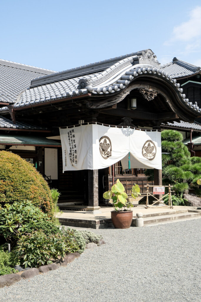 Gotokuji Temple grounds, showing another building with a white decorative flag in front