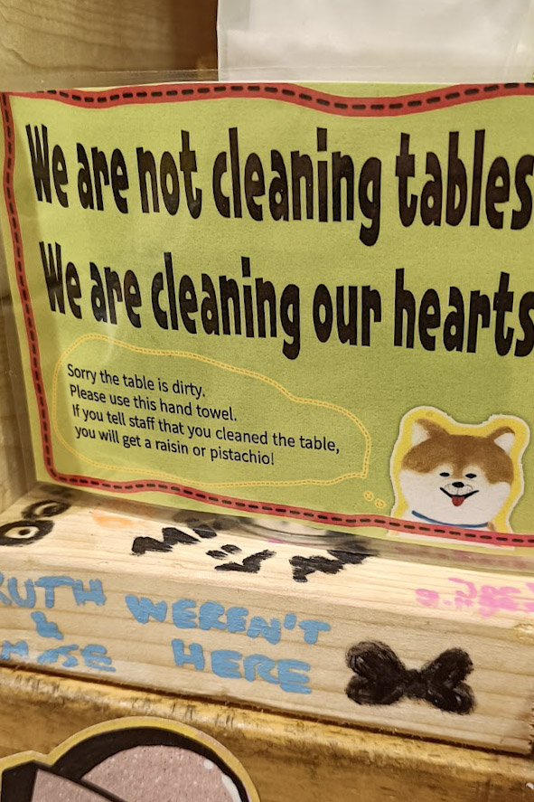A sign in OKO takoyaki that tells you if you clean the table, you'll be given a pistachio or raisin