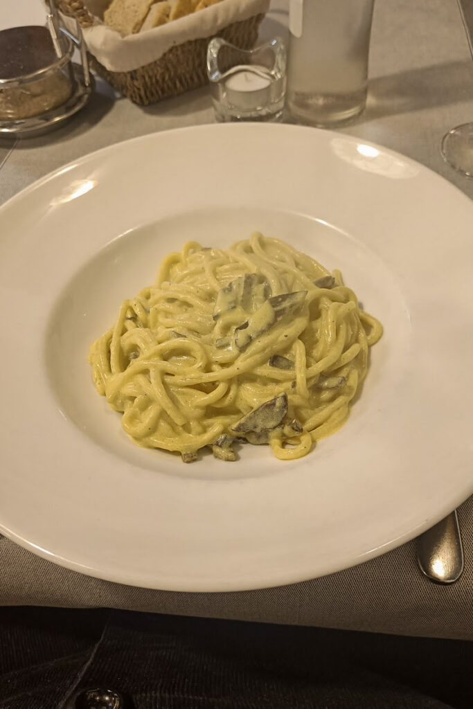 A plate of vegan carbonara pasta in La Lanterna, vegan restaurant in Verona