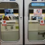 Train doors with advertisements and signage about Japanese train rules. Taken in a Tokyo metro train
