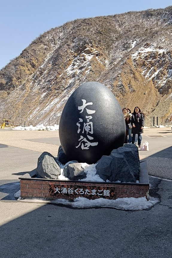 Large black egg sculpture with text in Owakudani, Hakone, Japan