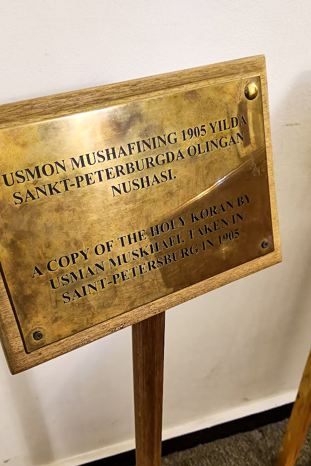 a sign explaining that the Quran next to it is a replica, in Tashkent Uzbekistan