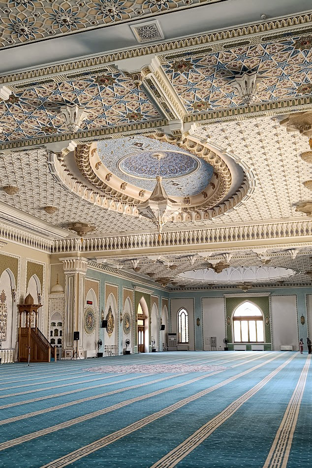 The blue interior of the Hazrati Imam mosque in Tashkent, Uzbekistan. showing soft blue carpet and ornate ceiling carvings