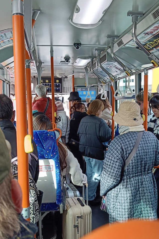 Crowded bus interior with passengers.