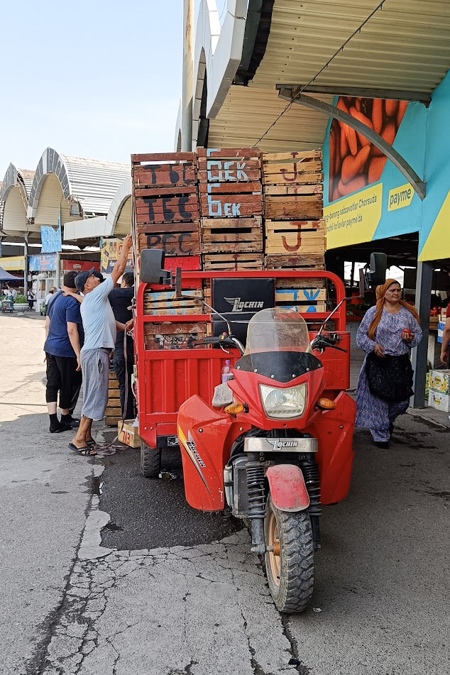 A truck piled high with wooden crates at Chorsu Bazaar in Tashkent, Uzbekistan