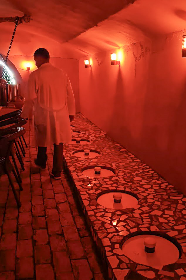 A red lit room with qvevri wine fermentation at Bagizagan winery in Uzbekistan