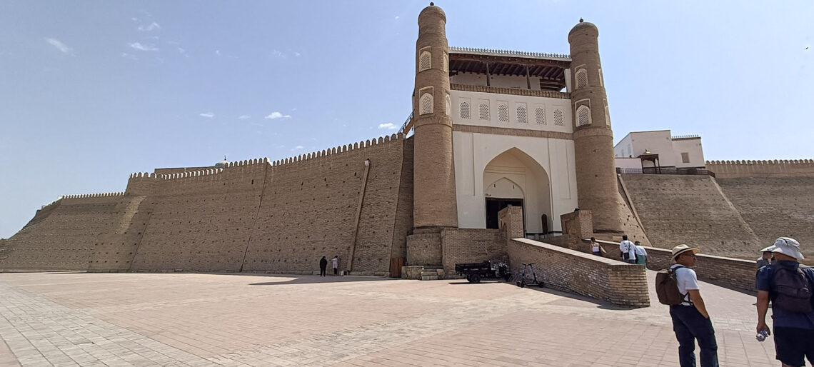 The imposing mud walled entrance to the the Ark of Bukhara, with a ramp up to the gate - something you'll need to see on a two days in Bukhara itinerary