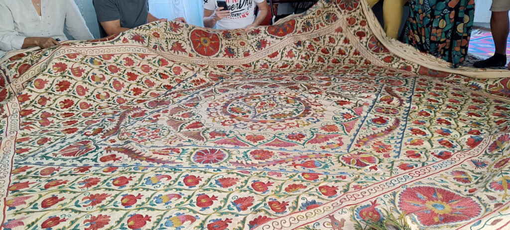 Colorful traditional embroidered fabric display in a Suzani embroidery workshop in Bukhara