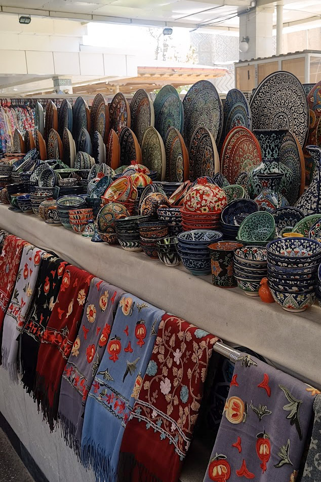 Ceramics and colourful scarves on a market stall in Siyob Bazaar, Uzbekistan