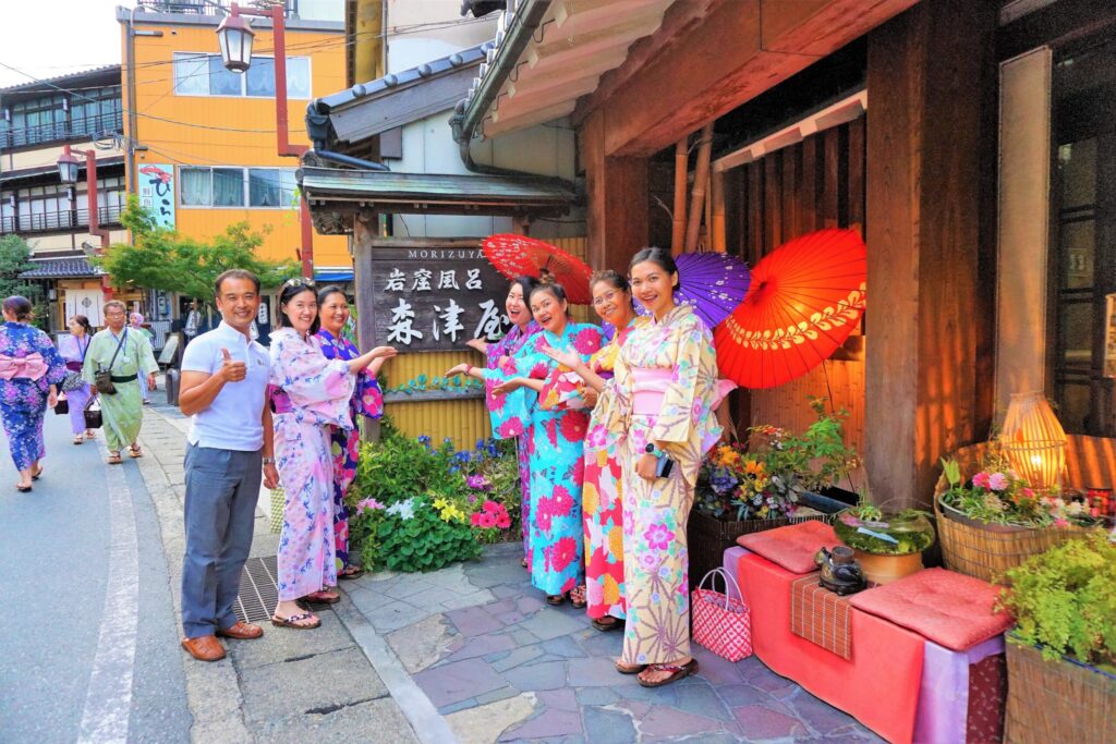People wearing colourful yukata robes outside the Morizuya ryokan in Kinosaki