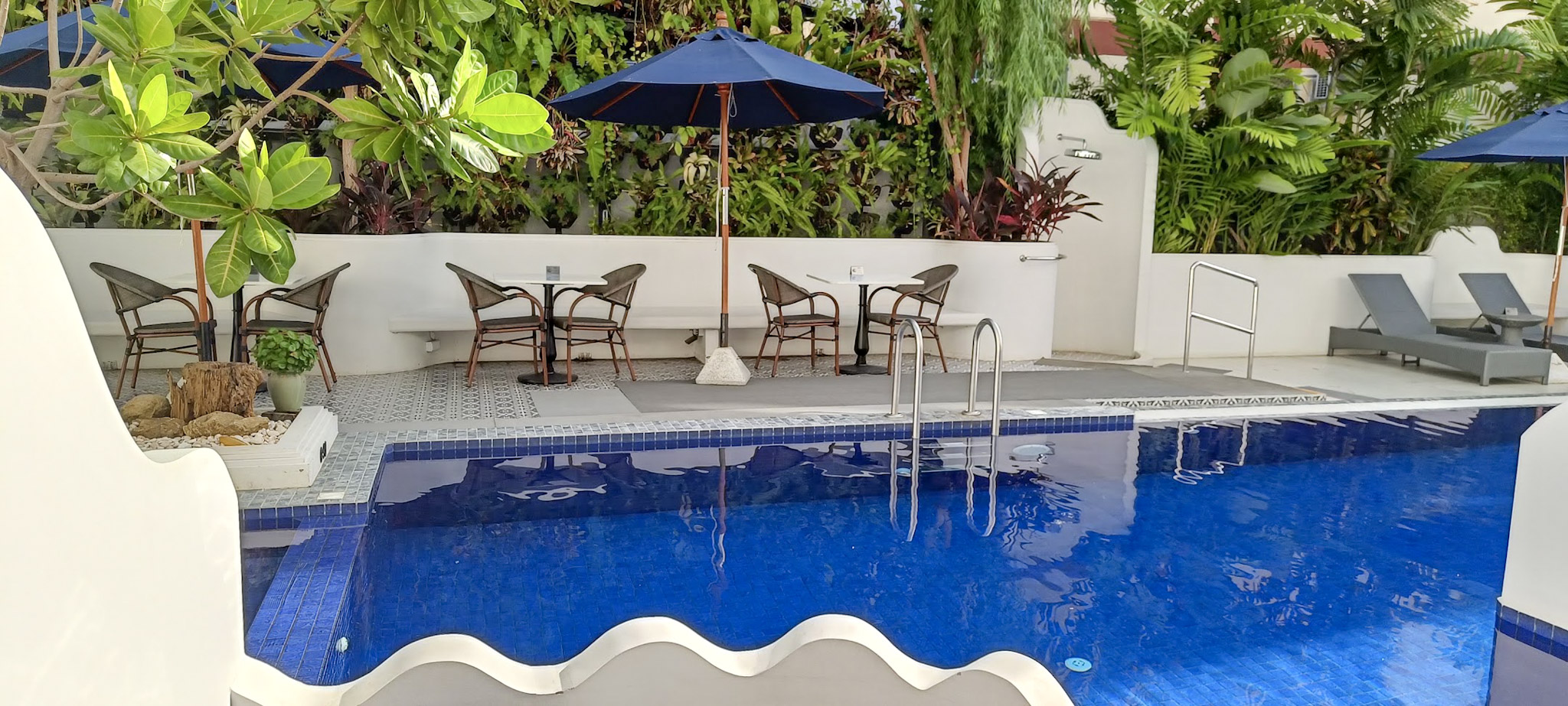 Serene poolside with tropical greenery.